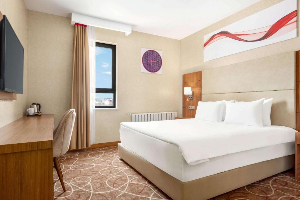 A bed or beds in a room at Ramada By Wyndham Elbistan