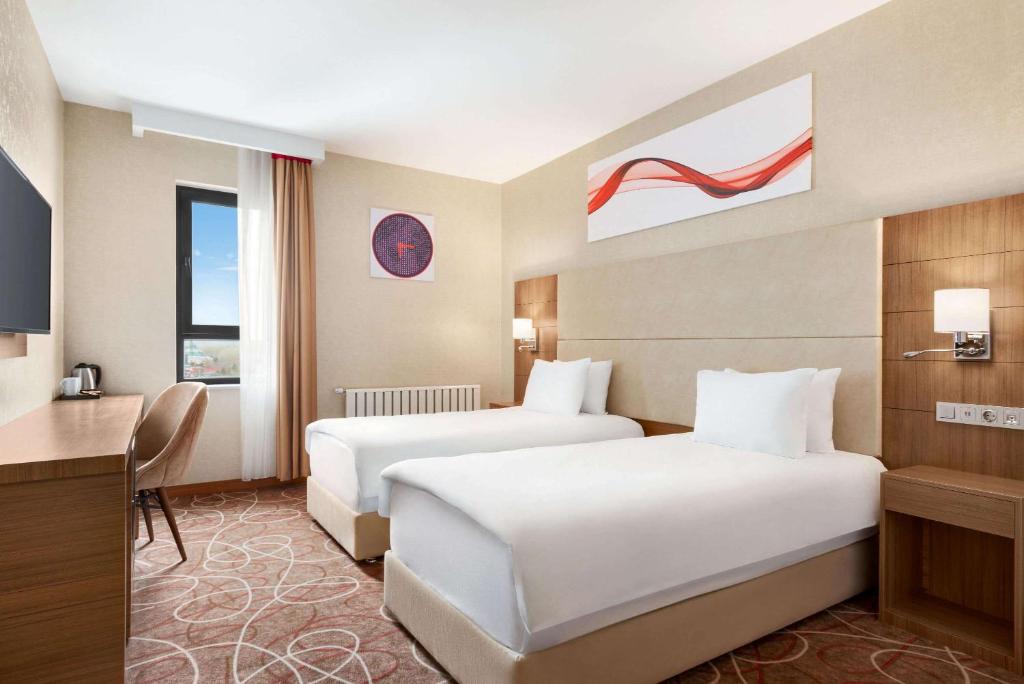 A bed or beds in a room at Ramada By Wyndham Elbistan