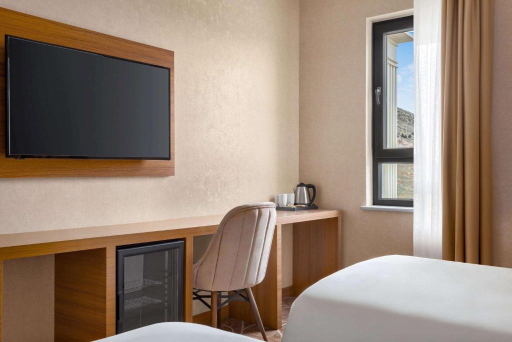 A bed or beds in a room at Ramada By Wyndham Elbistan