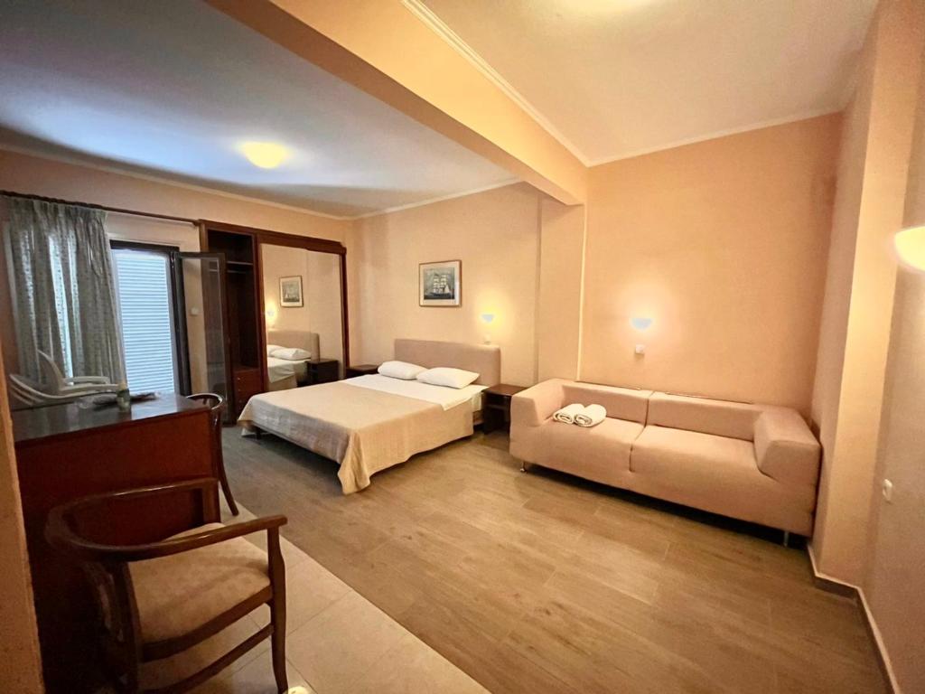 ein Hotelzimmer mit einem Bett und einem Sofa in der Unterkunft Saint George Hotel in Asprovalta