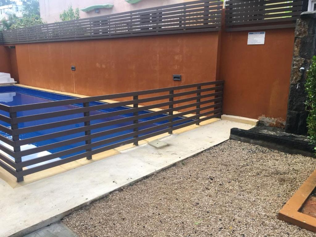 a fence on the side of a building at 2 bedrooms appartement at Flic en Flac 100 m away from the beach with shared pool furnished terrace and wifi in Flic-en-Flac