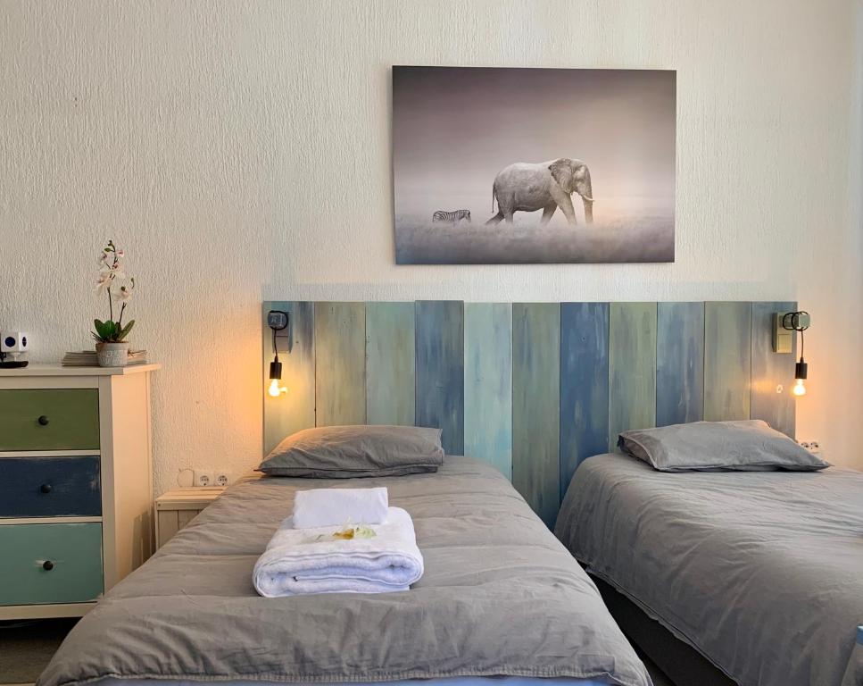 a bedroom with two beds and a picture of an elephant at Apartamentos RG Resitur in Seville