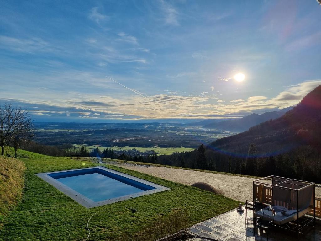 a swimming pool on top of a grassy hill at Berghotel & Chalets Adersberg Chiemgau Card kostenfrei in Grassau