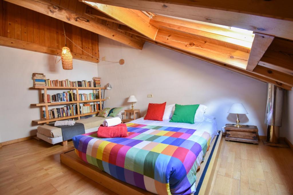 sypialnia z dużym łóżkiem z kolorowymi poduszkami w obiekcie Ca La Rougvie w mieście Esterri d'Àneu