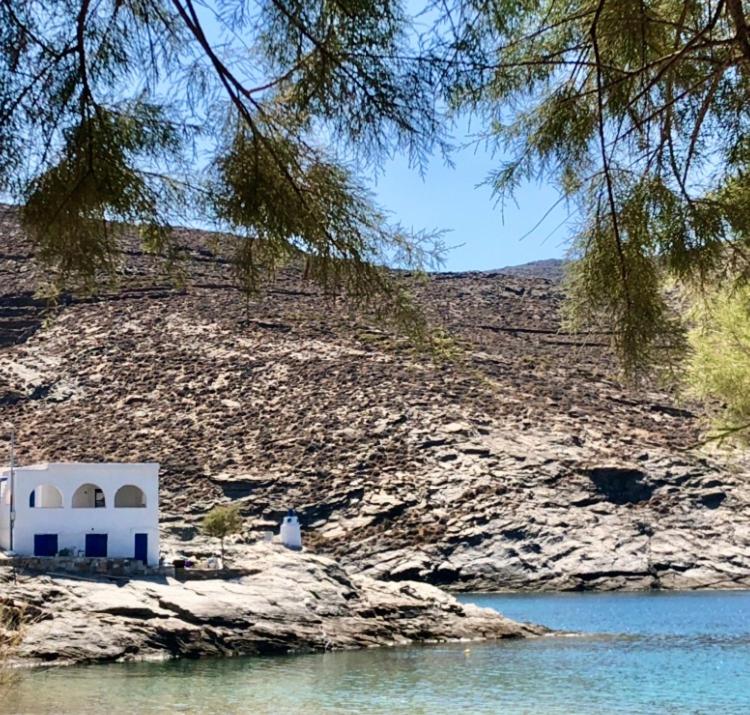 a building on a rocky hill next to a body of water at Malli Sea House in Mamádhos