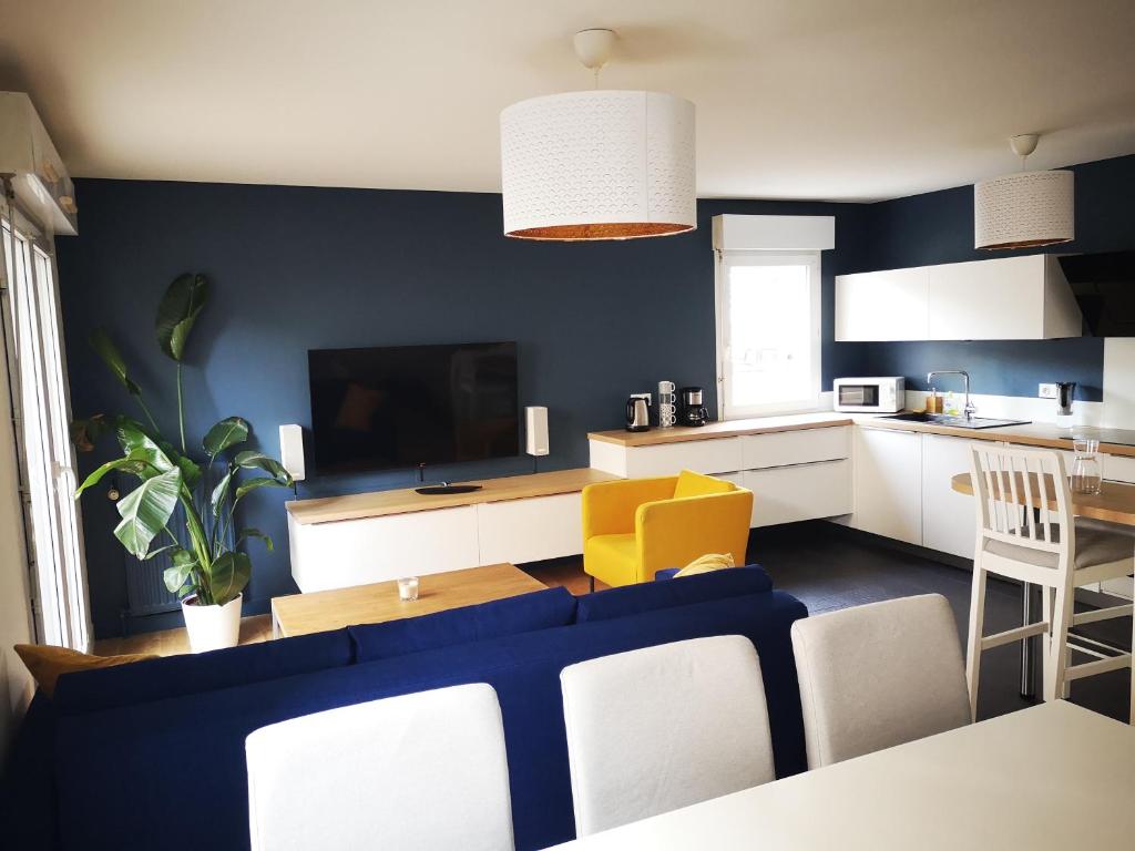 een woonkamer met een bank en een keuken bij Appartement T3 centre ville Mabilais au calme. in Rennes