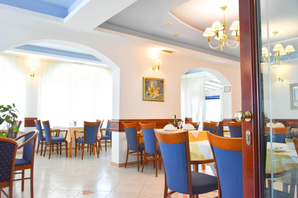 una sala da pranzo con tavolo e sedie di Hotel Adria a Kaštela (Castelli)