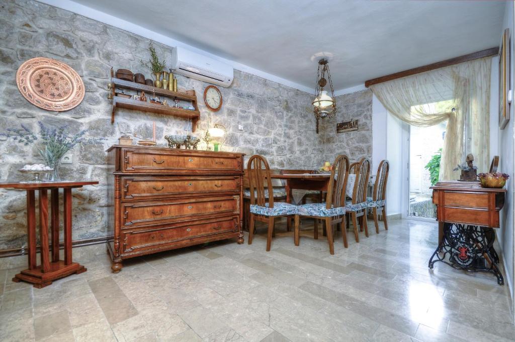ein Esszimmer mit einer Holzkommode und einem Tisch in der Unterkunft Stara Lipa in Baška Voda