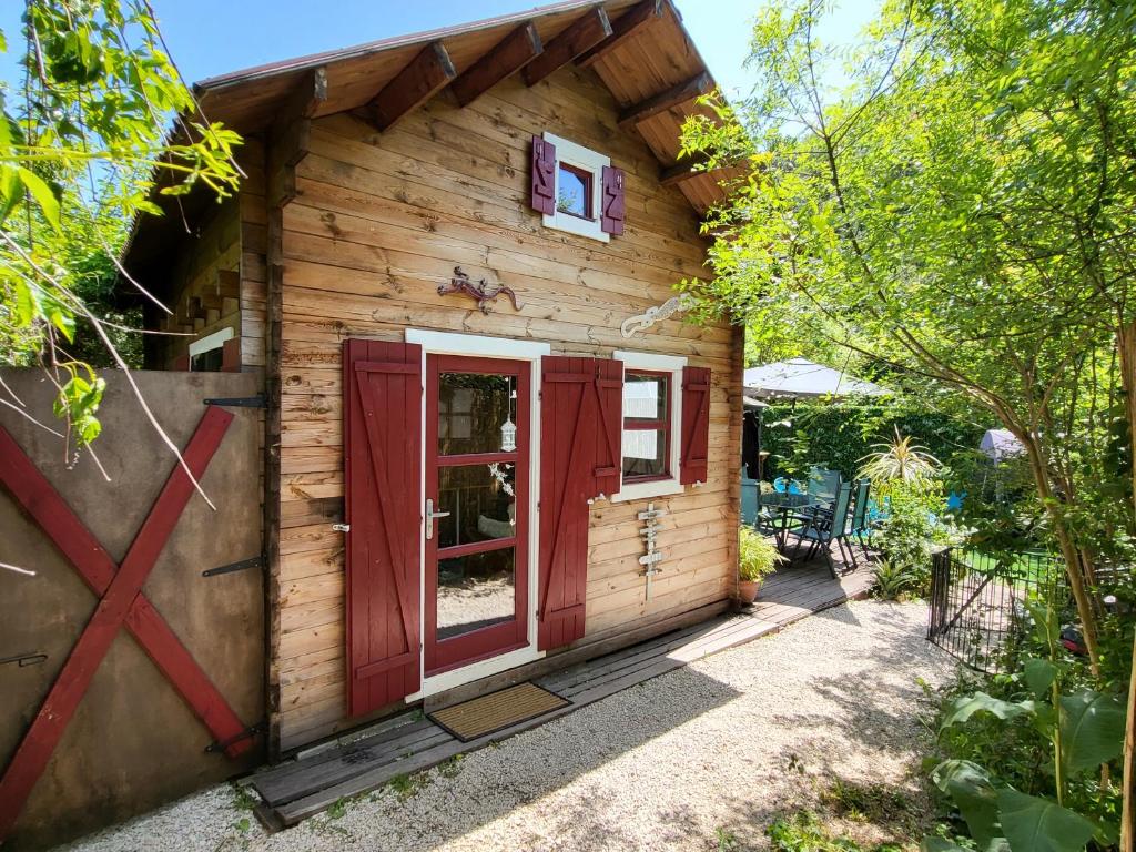 a log cabin with red doors and a window at le petit chalet cevenol in La Barriére