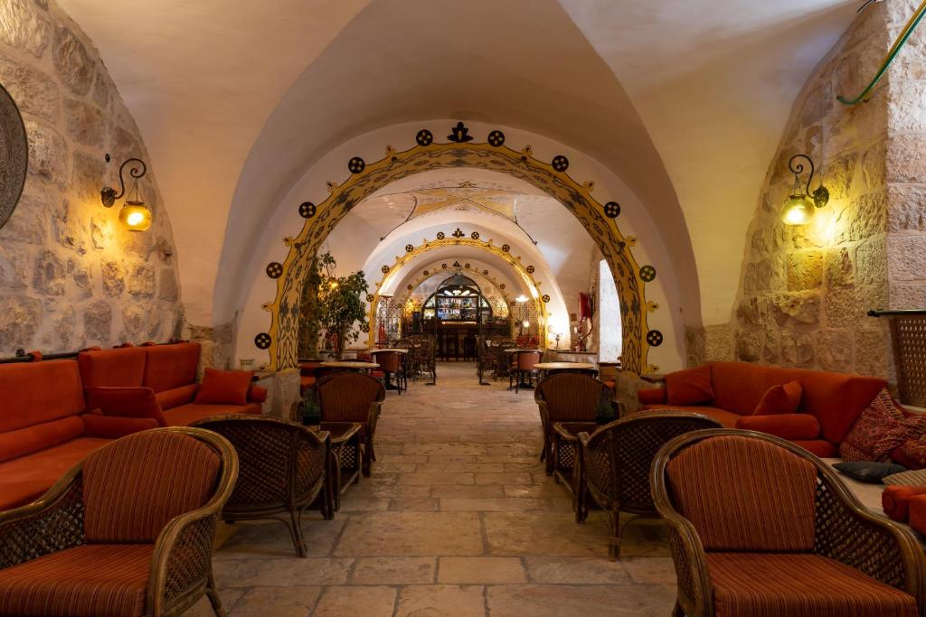 a restaurant with orange chairs and tables in a building at Gloria Hotel in Jerusalem