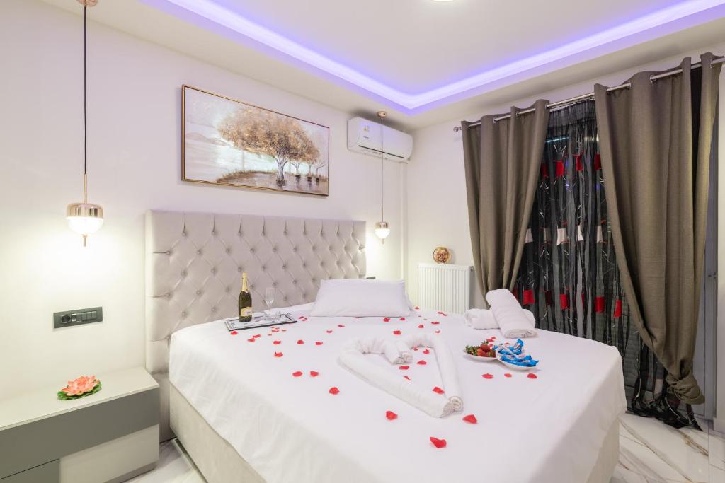 a bedroom with a white bed with flowers on it at Alkeos Suite in Zakynthos Town