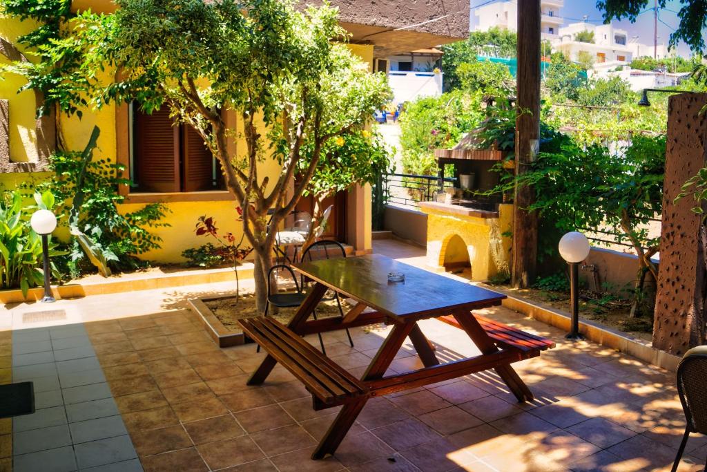 einen Holztisch und eine Bank auf einer Terrasse in der Unterkunft Fotula Studios in Agia Pelagia