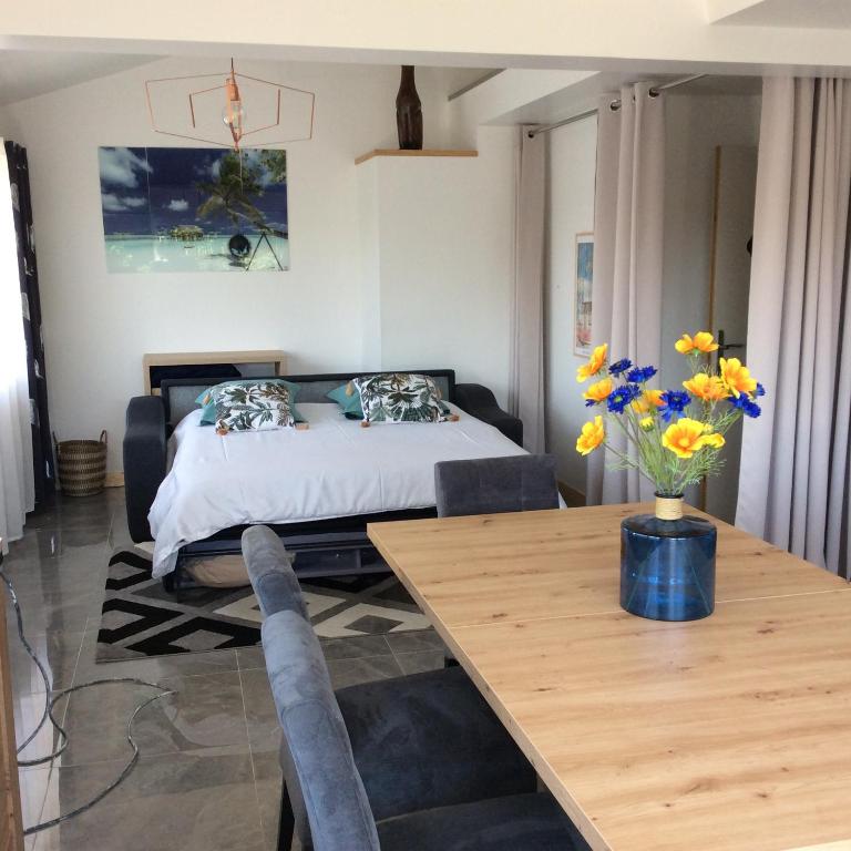 a bedroom with a bed and a table with flowers at bienvenue chez Alain et Marie in Antibes