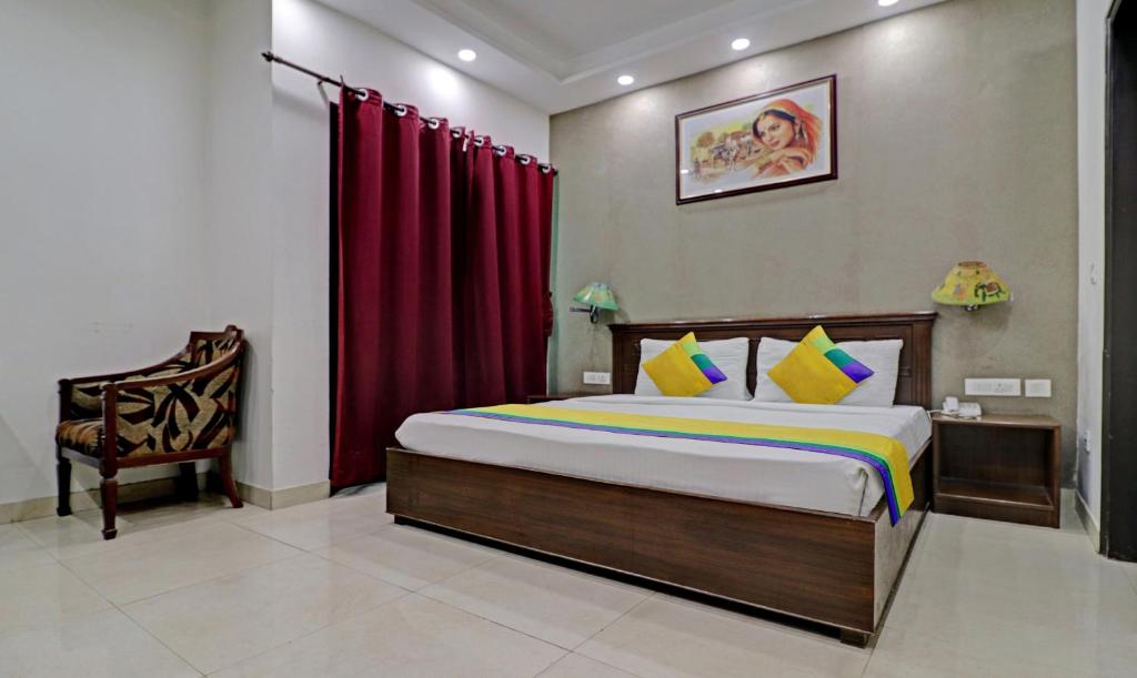 a bedroom with a large bed and a chair at Itsy By Treebo - Hamlets Stay in Noida