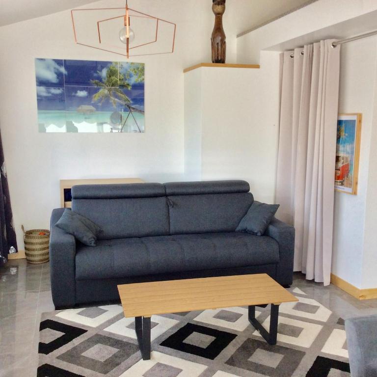 a living room with a blue couch and a coffee table at bienvenue chez Alain et Marie in Antibes