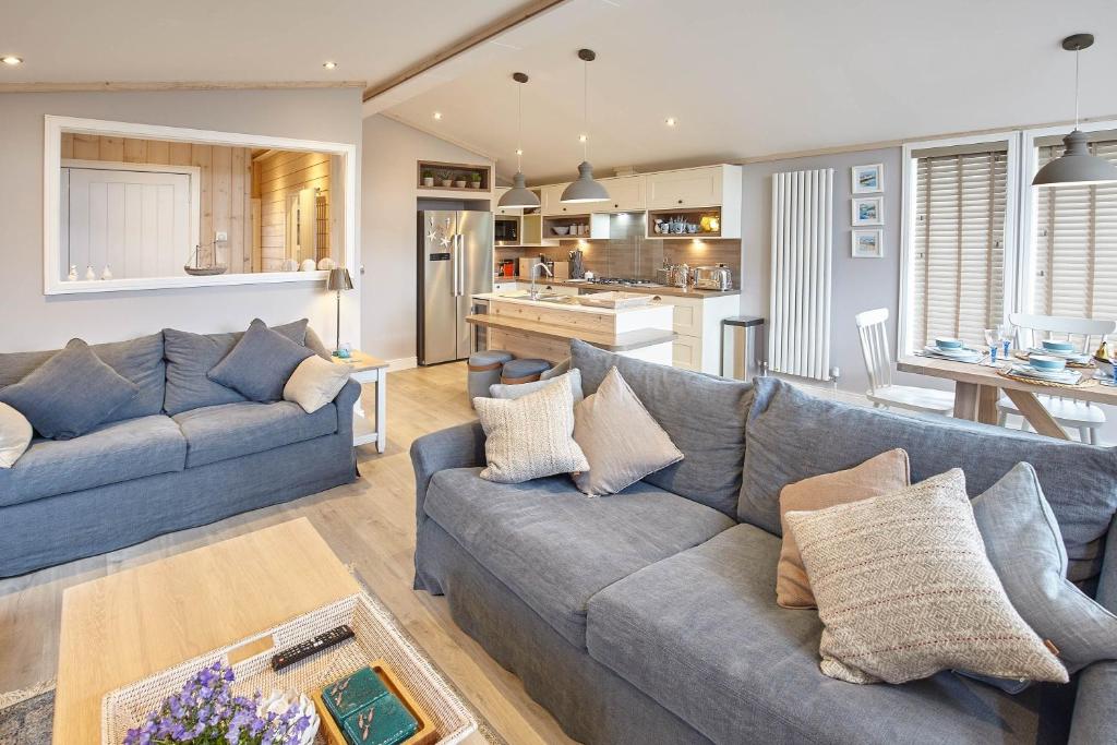 a living room with two couches and a kitchen at Host & Stay - Puffins Rest in Runswick