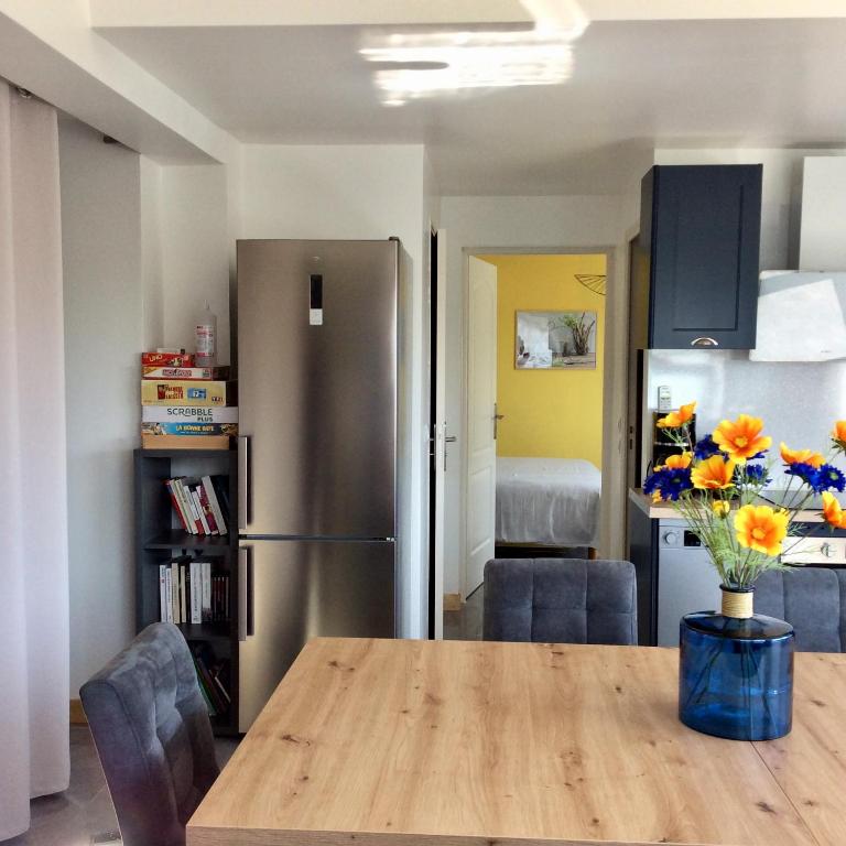 a kitchen with a wooden table and a refrigerator at bienvenue chez Alain et Marie in Antibes