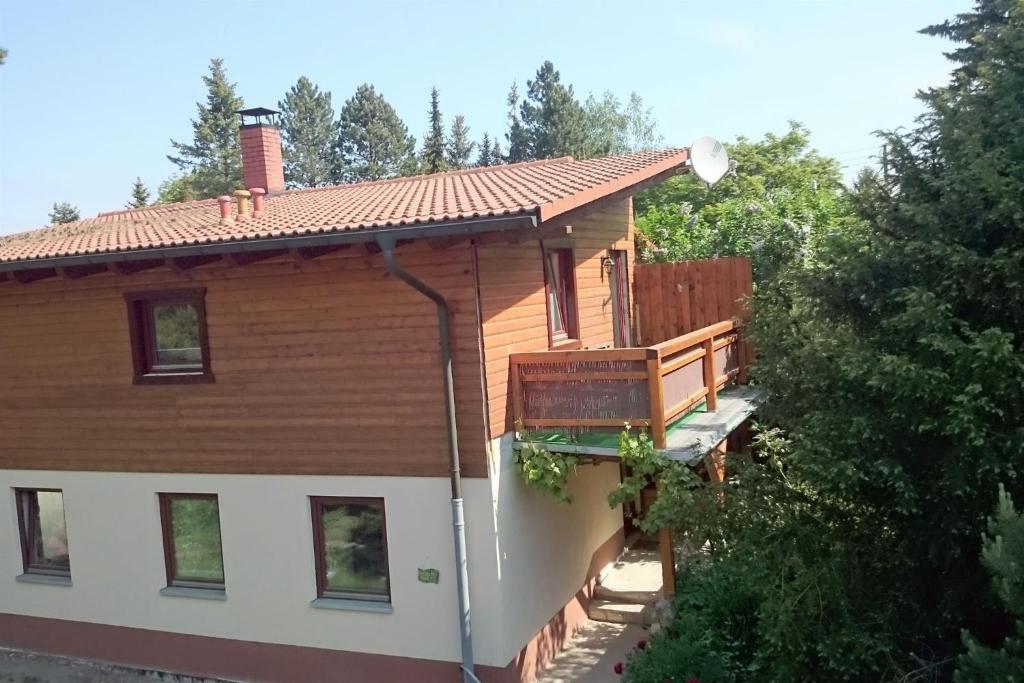 une maison en rondins avec une véranda et une terrasse dans l'établissement Ferienwohnungen Marle, à Struppen