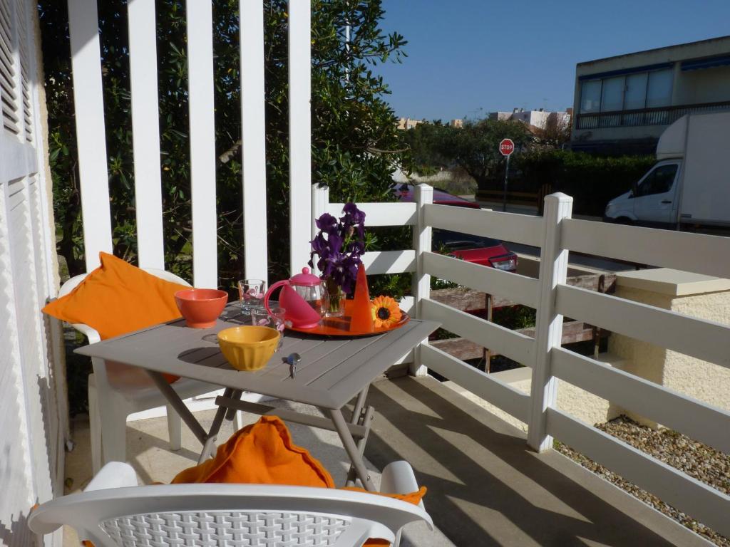 d'une table et de chaises sur un balcon avec une clôture. dans l'établissement Sol-y-Days Yucca, Agreable appartement en RDC avec petite terrasse et parking à 150m de la plage, au Grau-du-Roi