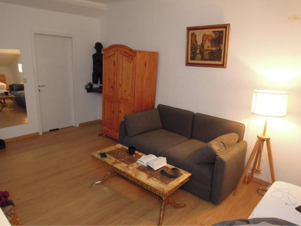 uma sala de estar com um sofá e uma mesa de centro em FERTILE em Charleroi