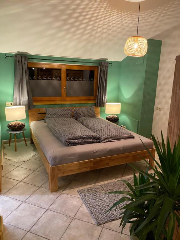 a bed in a room with a green wall at Sepps Appartement in Fieberbrunn