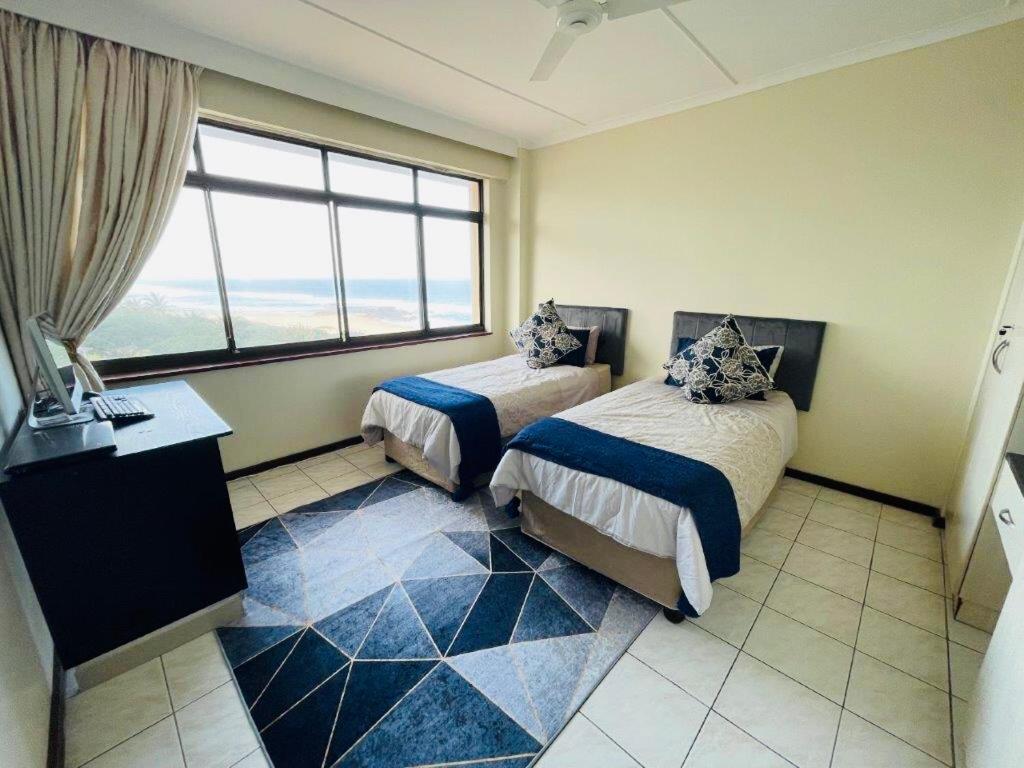 a hotel room with two beds and a window at Penthouse 42 at Ezulweni in Amanzimtoti