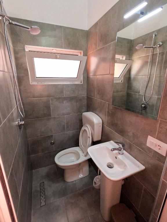 a bathroom with a toilet and a sink and a shower at InTown Guesthouse Shkoder in Shkodër