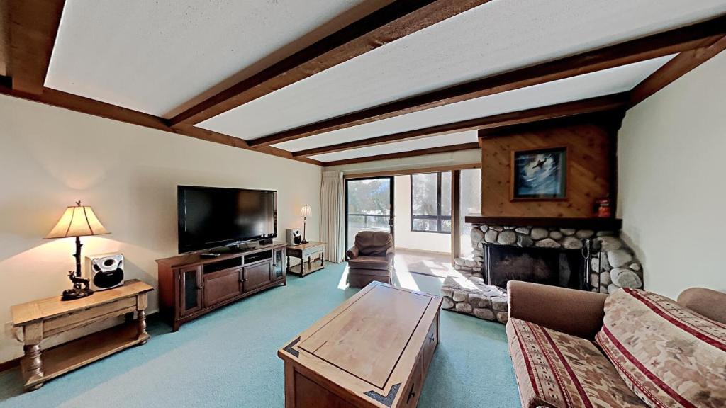 a living room with a tv and a fireplace at Slopeside 1849 Condos - Comfortable 3 BR Condos with Full Kitchens in Mammoth Lakes