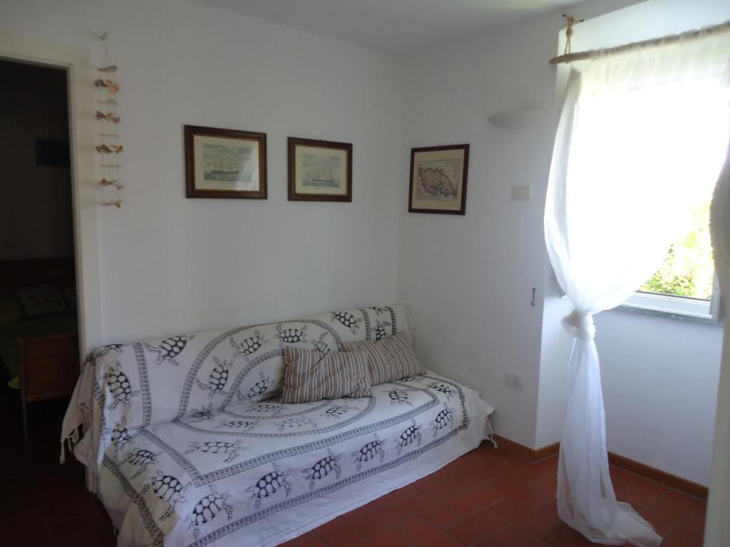 uma sala de estar com um sofá e uma janela em Voglia di mare em Ilha Capraia