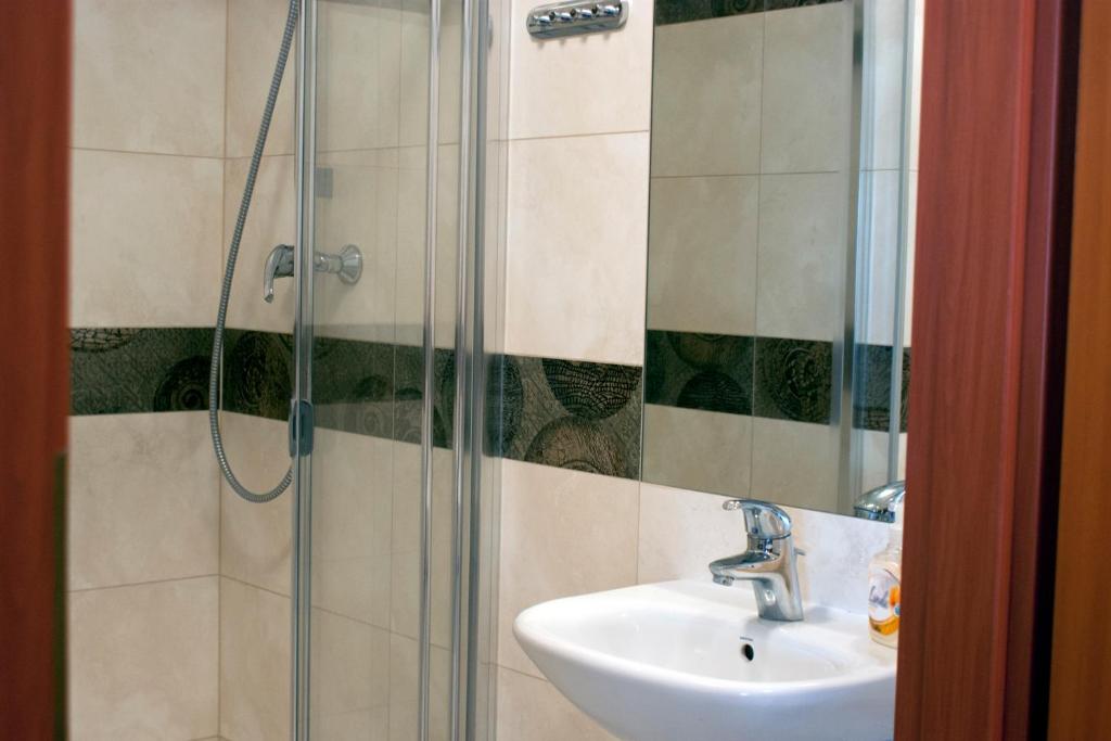 uma casa de banho com um lavatório e uma cabina de duche em vidro. em Apartament Cafe Del Mar em Świnoujście