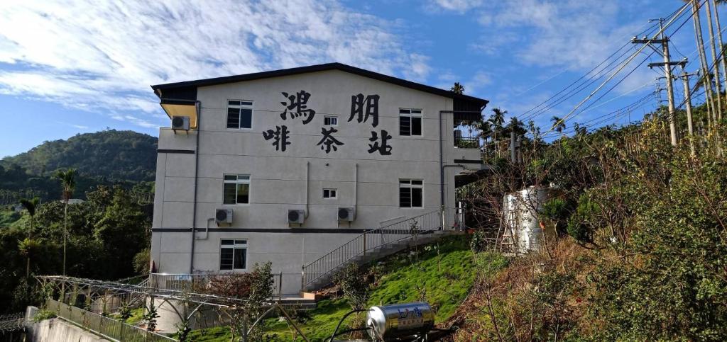 a building with asian writing on the side of it at Hongpeng Coffee Station Homestay in Meishan