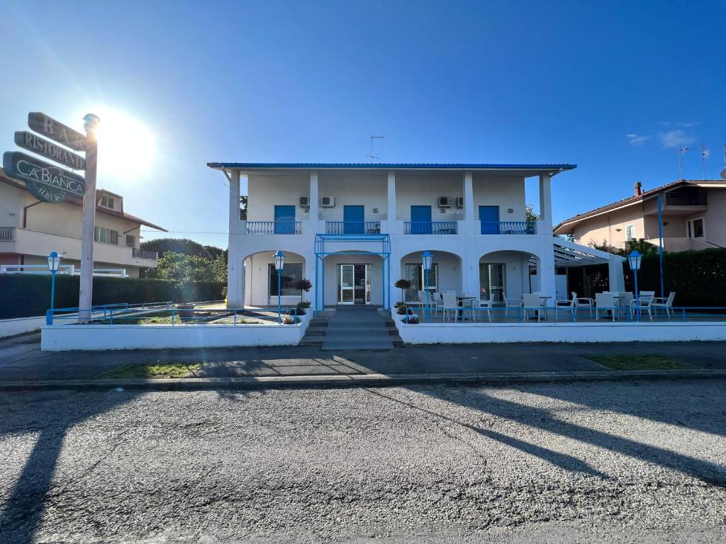 un edificio blanco con acentos azules en una calle en Hotel Ca' Bianca da Paolino, en Misano Adriatico