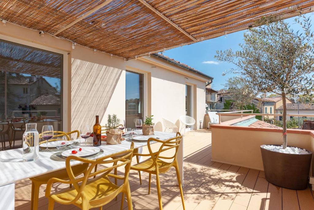 a patio with a table and chairs on a deck at Lunam Penthouse in centre in Lucca