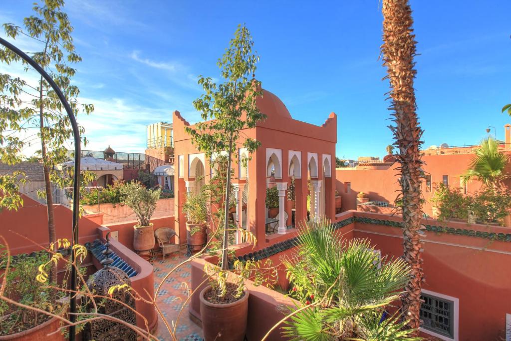 een resort met palmbomen en een gebouw bij Riad Kaiss By Anika in Marrakesh
