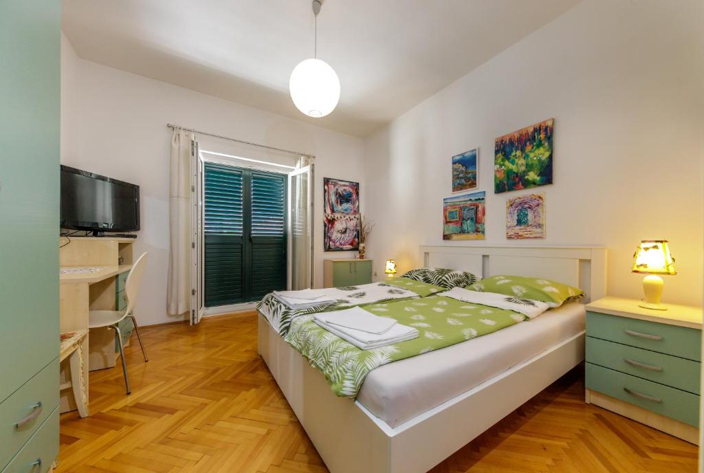 Dormitorio con cama, escritorio y TV en Apartment Tolja, en Dubrovnik