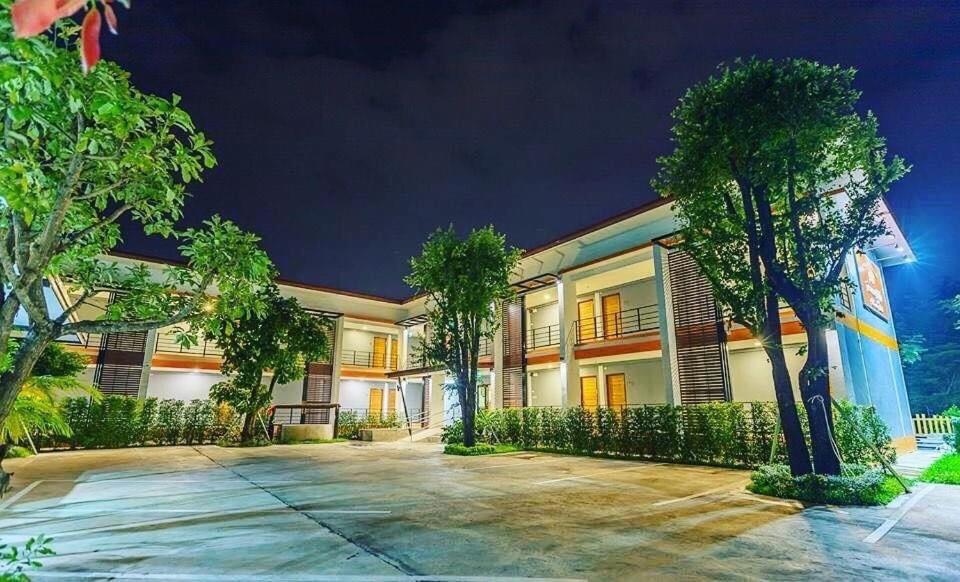 a large building with trees in front of it at Barista Hotel in Uttaradit