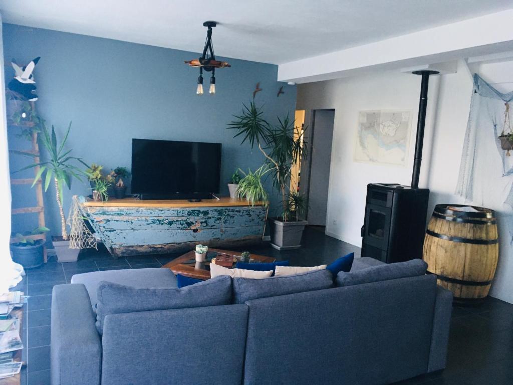 a living room with two couches and a flat screen tv at Maison LE BONO KERBISOUNOURS in Le Bono