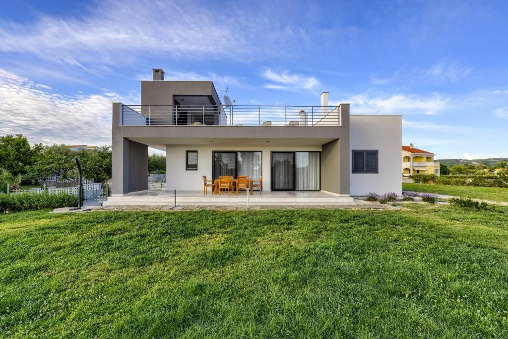 uma casa com um grande relvado em frente em Haus Cvita em Ražanac