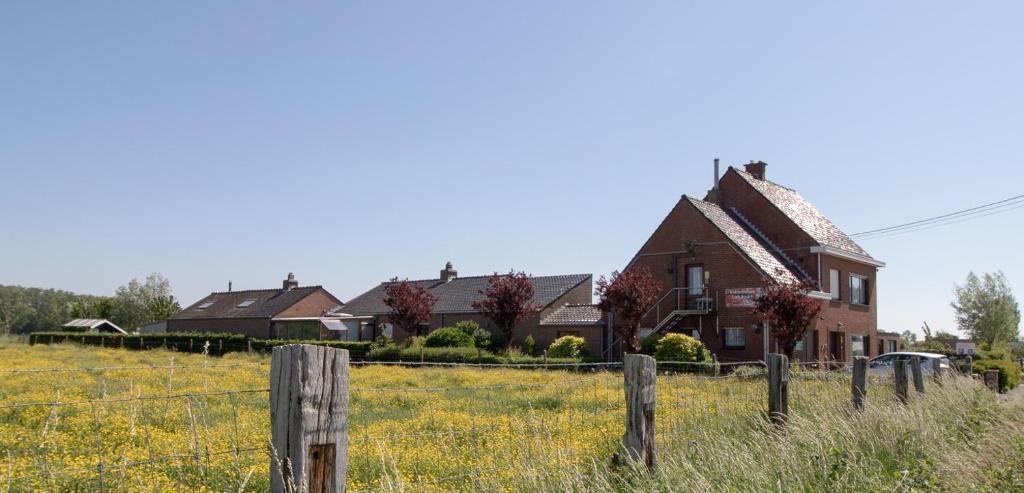 une maison dans un champ à côté d'une clôture dans l'établissement Vakantiehuis Lappersfort, à Dixmude