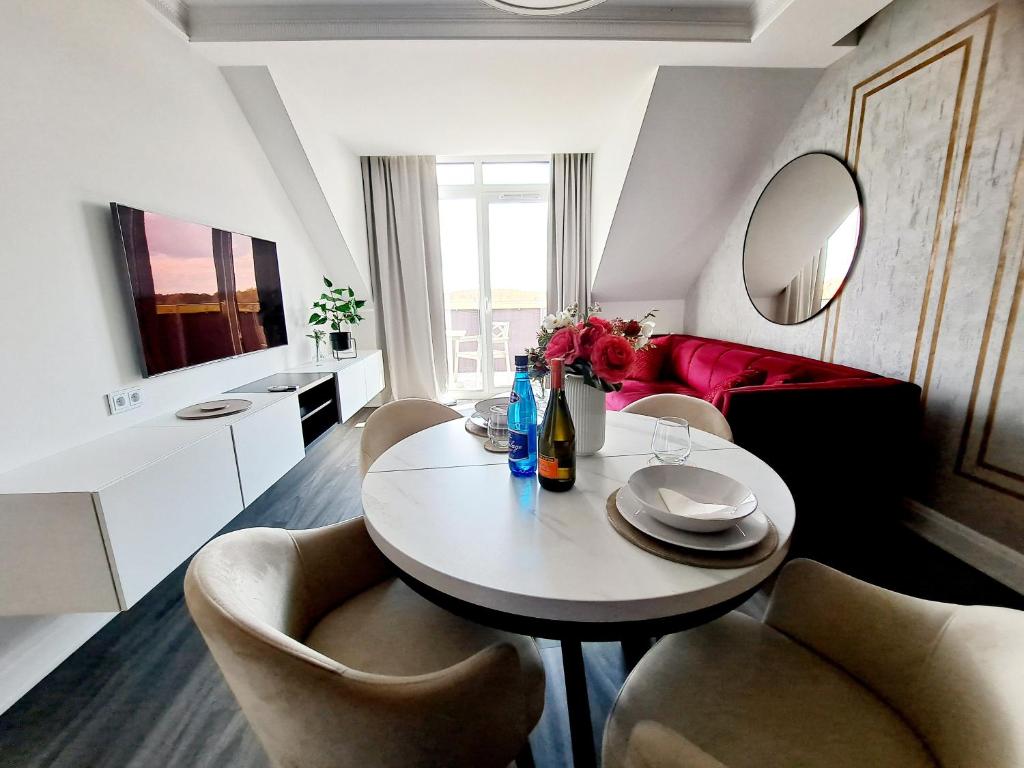 a living room with a table and chairs and a red couch at Apartament Węgorzewo in Węgorzewo