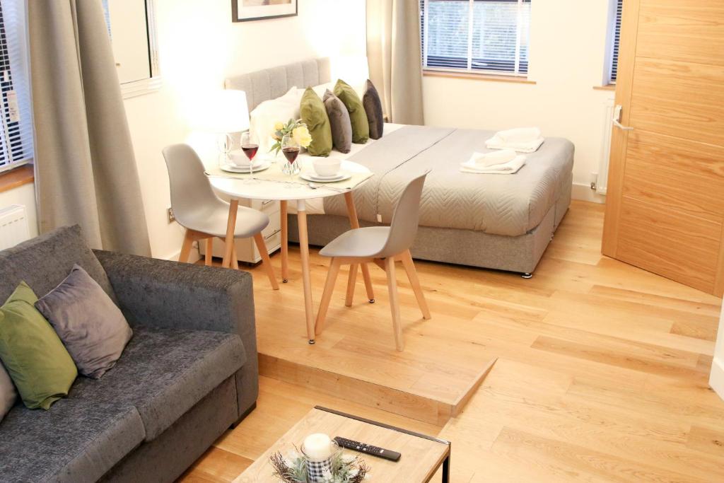 uma sala de estar com um sofá e uma mesa em Lovely Studio Apartment with access for Wheel-chairs in Sydenham em Forest Hill