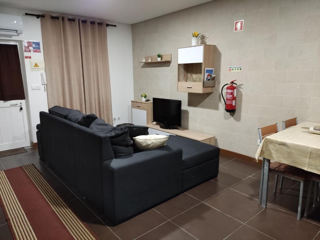 a living room with a black couch and a table at Holiday home and weekends, 4 in Esposende