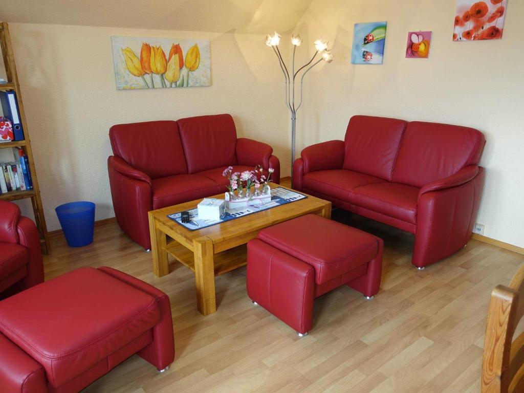 a waiting room with red chairs and a table at Ferienwohnung Heike in Rabel
