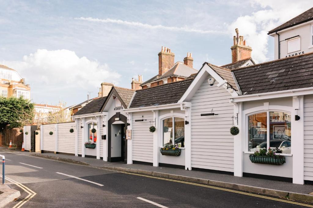 a row of white buildings on a street at Ashbys Accommodation & Spa hire in Portsmouth