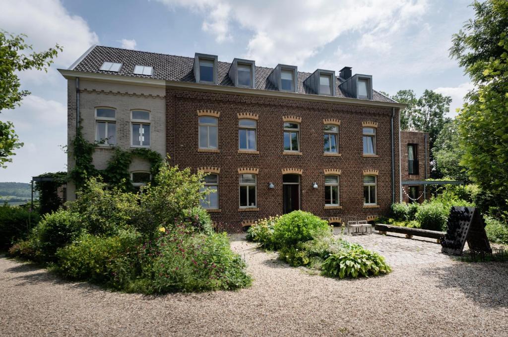 een groot bakstenen gebouw met ramen erop bij Domein Holset BruisendWijnHuis in Lemiers