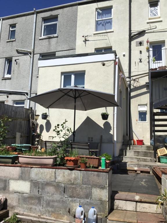 an umbrella sitting in front of a building at Apartment with shared garden and basic equipments in Plymouth