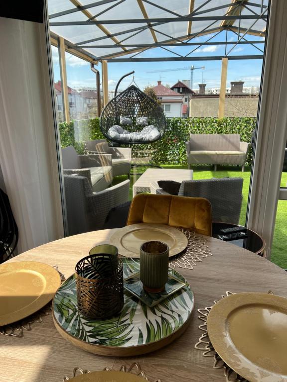 a table with plates and bowls on it on a patio at Comfort Zone Ostróda Villa Apartment Duplex in Ostróda