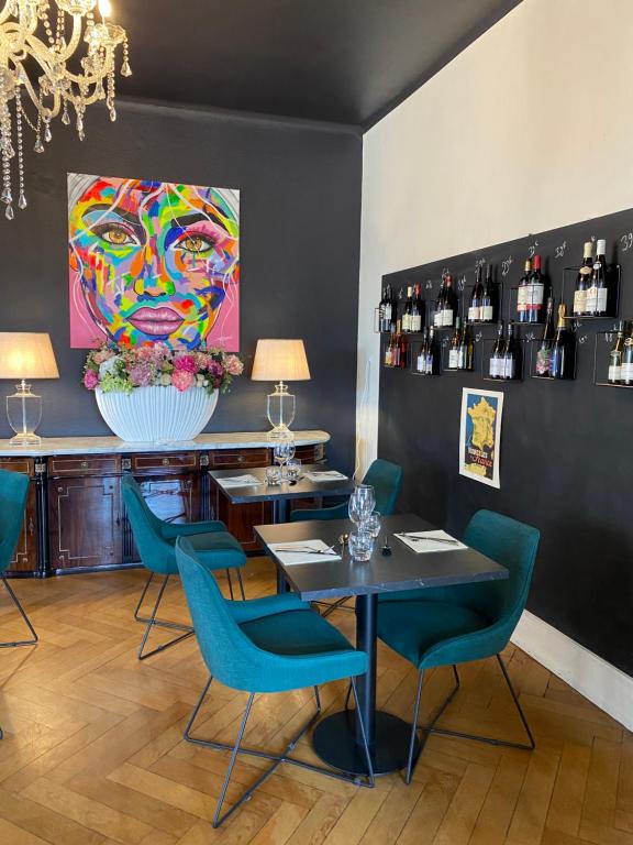 Un comedor con una mesa y sillas y un cuadro. en LA VILLA Hôtel-Restaurant, en Saverne