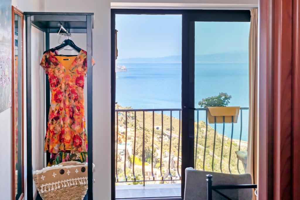 un vestido colgado en un balcón con vistas al océano en La Casa Gialla, en Taormina