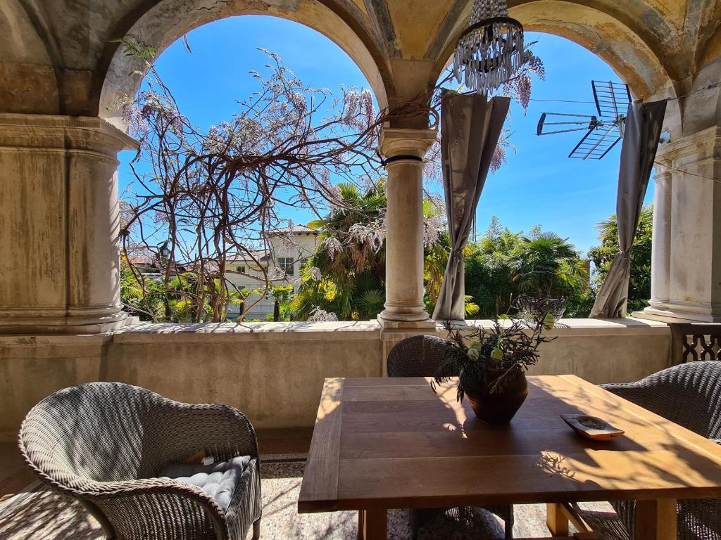 a table and chairs in a porch with a view at Heritage Apartment Park Royal Residence in Opatija